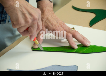 ältere Frau schneiden Glasmalerei von hand Stockfoto