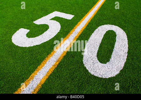 Nummer 50 50-Yard Linie Marker auf grüne Fußballplatz mit weißen und gelben Streifen Stockfoto