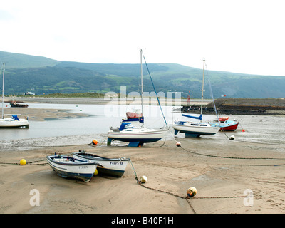 Die Fähren und Yachten vor Anker zusammen, bei Ebbe im Hafen von Barmouth, Wales, Vereinigtes Königreich. Stockfoto