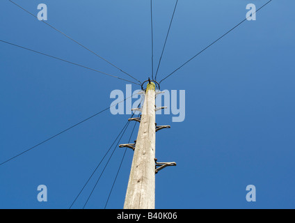 Hölzerne Telegrafenmast gegen blauen Himmel Stockfoto