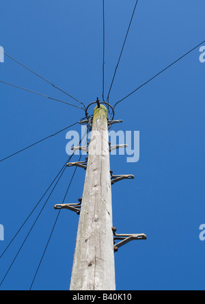 Hölzerne Telegrafenmast gegen blauen Himmel Stockfoto