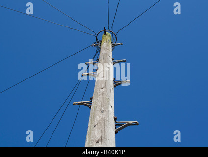 Hölzerne Telegrafenmast gegen blauen Himmel Stockfoto