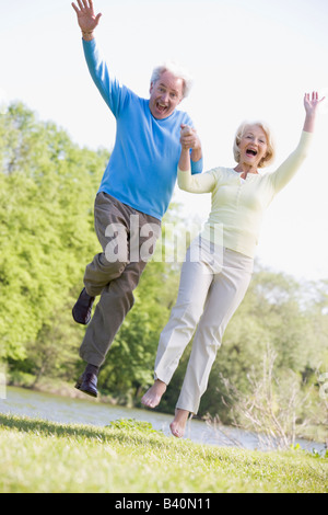 Paar im Freien im Park von lächelnden See springen Stockfoto