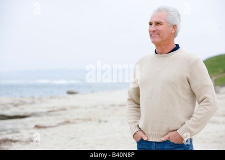 Mann am Strand mit Händen in den Taschen Stockfoto