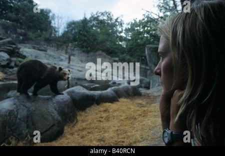 Jüngere Frau beobachten Braunbär Ursus Arctos im Tiergehege Mundenhof Skansen Park Stockholms Lan August 2006 Stockfoto