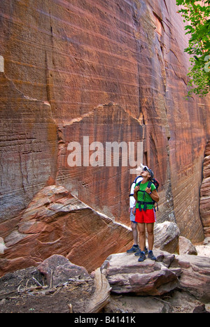 USA, Utah, Zion Park.  Zwei Wanderer starren bis an die Felswände des Hidden Canyon.  (MR) Stockfoto