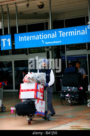 Sihk indischen Taxifahrer Räder eine Passagiere Gepäck vom internationalen Terminal am Flughafen Sydney s Maskottchen Stockfoto