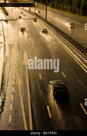 Autobahn oder Autobahn Fahrzeuge und Verkehr am Abend Regen Sturm, während die Straßen nass und gefährlich sind Stockfoto