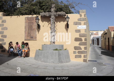 Vier junge Mädchen sitzen einen Chat neben ein Denkmal für die Gefallenen des spanischen Bürgerkrieges in Aguimes, Gran Canaria Stockfoto