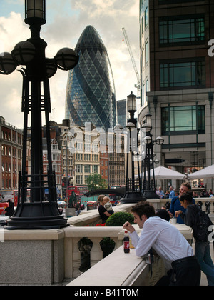 Londoner und Touristen mit einer Pause in Bishopsgate mit Gurke im Hintergrund London Vereinigtes Königreich Stockfoto