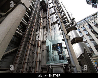 Mann in externen Glasaufzug von der Lloyds Gebäude in der Stadt London UK Stockfoto