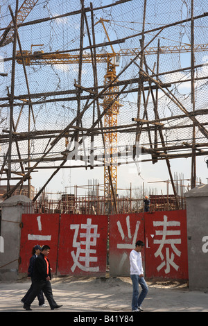 Menschen zu Fuß vorbei an einer Baustelle, Peking, China Stockfoto