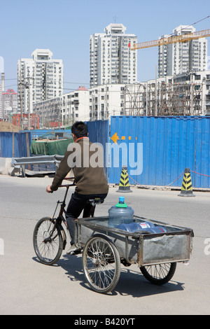 Rikscha-Fahrer fahren entlang einer Bau Website Horten, Peking, China Stockfoto