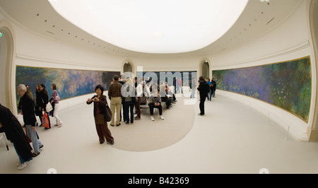 Touristen und Besucher bewundern die Nympheas Gemälde von Claude Monet im Musee de L Orangerie Tuileries Paris Frankreich Europa Stockfoto