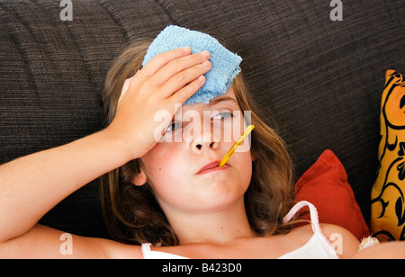 Kleines Mädchen mit Thermometer im Mund Stockfoto