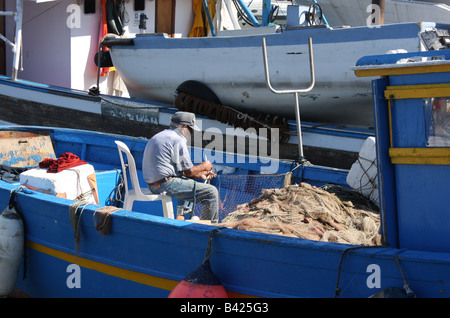 Ein Fischer prüft seine Netze im Hafen von Pozzuoli in Süditalien Stockfoto