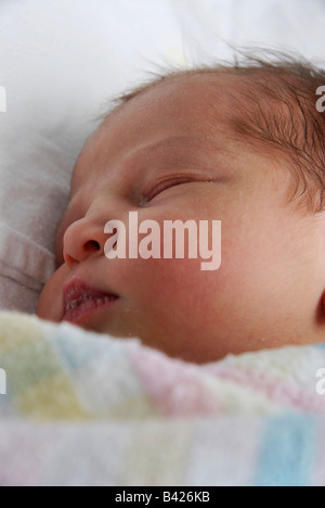 Nahaufnahme eines neugeborenen Babys schlafen, während in Decken gewickelt Stockfoto