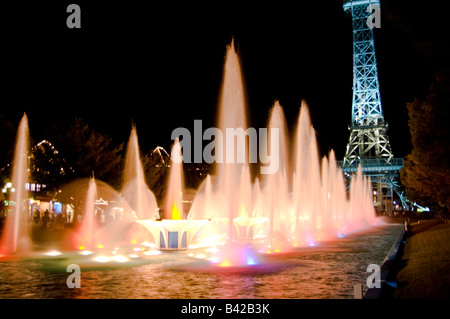 Schöne leuchtende Fontänen sind nachts beleuchtet, wie den Eiffelturm im Hintergrund glänzt. Stockfoto