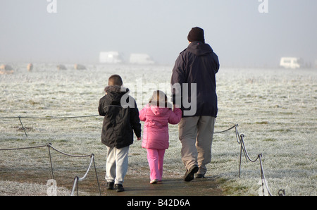Ein Mann und seine Kinder zu Fuß auf einem Weg an einem frostigen Morgen Stockfoto