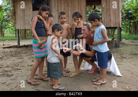 Ein Tourist zeigt einheimische Kinder aus einem Dorf von den Madeira Fluss-Bildern, die sie auf einer digitalen Kamera von ihnen genommen hat. Stockfoto