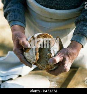 Mann brechen Brot Stockfoto