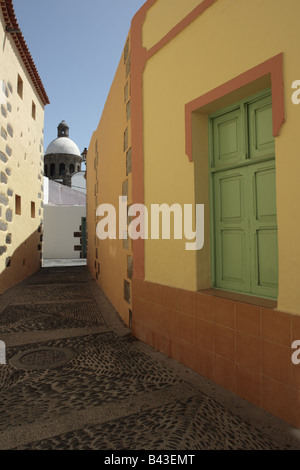 In einer Gasse zwischen zwei Altbauten an der Kuppel auf die Kirche von San Sebastian in Aguimes, Gran Canaria anzeigen Stockfoto