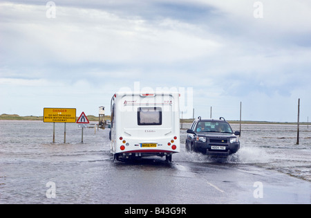 Verkehr fahren durch stehendes Wasser auf einem überfluteten Holy Island Damm Northumberland Großbritannien Großbritannien 2008 Stockfoto