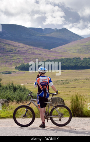 Radfahrer tragen Zyklus Racer tragen aerodynamischen Helm Landschaft Radrennen, Moorland Road, Aberdeenshire, Schottland UKadmiring der Blick auf Surround Stockfoto