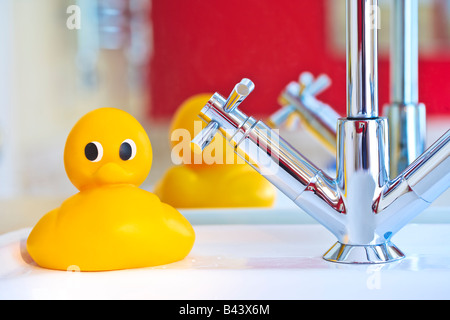 Gelbe Gummiente sitzt auf einem modernen Spültisch im heimischen Badezimmer Stockfoto