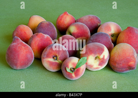 Frische Pfirsiche auf grünem Hintergrund Stockfoto