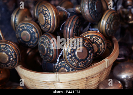 Ein Weidenkorb Messing Türklinken auf dem Display in eine architektonische Antiquitäten Shop Stockfoto