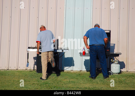 Zwei Männer grillen Fleisch im freien Stockfoto