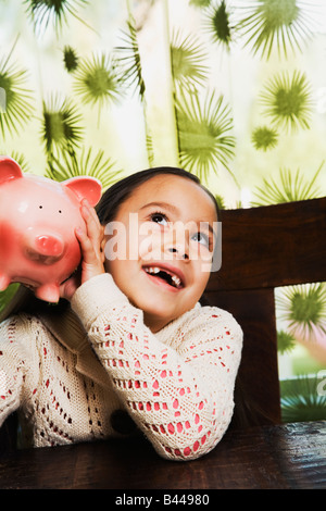 Asiatin schütteln Sparschwein Stockfoto