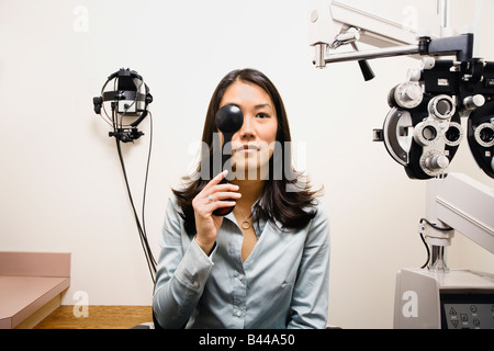 Asiatische Frau, die die Augenuntersuchung Stockfoto