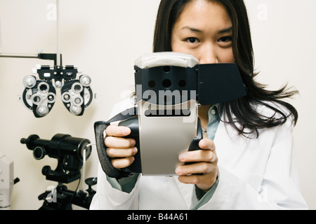 Asiatische Frau Optiker halten Ausrüstung Stockfoto