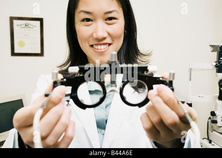 Asiatische Frau Optiker halten Ausrüstung Stockfoto