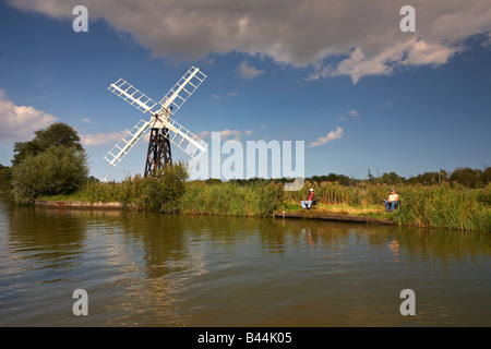 Zwei Fischern, die neben Boardmans traditionellen hölzernen Entwässerung Mühle / Windmühle auf dem Fluss Ant, Norfolk Broads Stockfoto