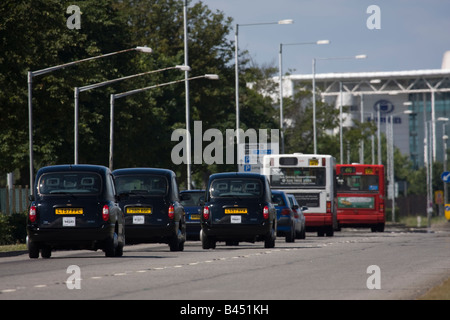 Taxis und Busse auf Southern Perimeter Road in der Nähe von Heathrow Airport, London UK. Stockfoto