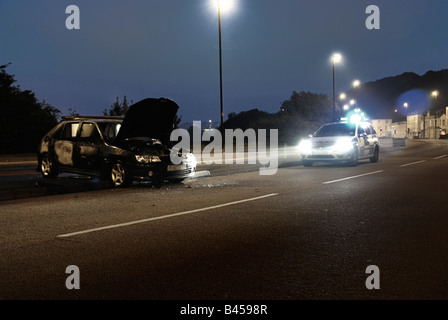 Auto von der Polizei in den frühen Stunden des Morgens besucht ausgebrannt Stockfoto