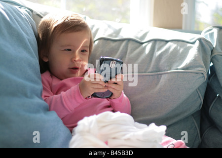 Eine 17 Monate altes Kleinkind Mädchen freut sich per e-Mail, die sie auf einem Blackberry-Gerät liest. Stockfoto