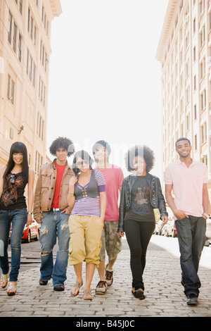 Multi-ethnischen Freunde städtischen Bürgersteig hinunter Stockfoto