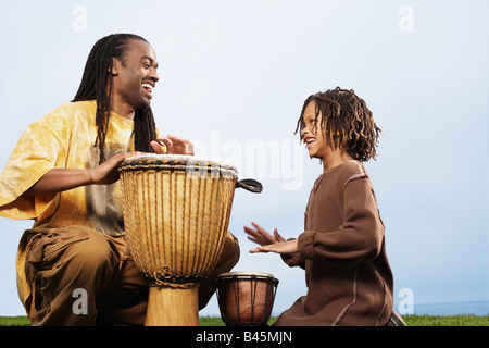 Afrikanischen Vater und Sohn Schlagzeug spielen Stockfoto