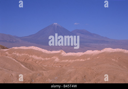 Felsformationen im Valle De La Muerte (Cordillera de Sal), Licancabur und Juriques (hinten) Vulkane im Hintergrund, in der Nähe von San Pedro de Atacama, Chile Stockfoto