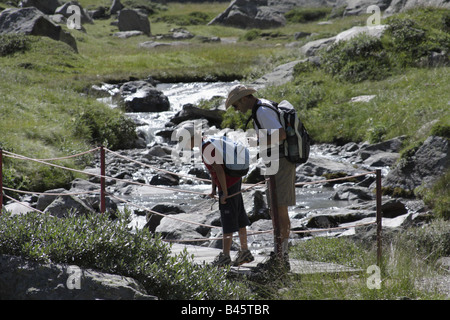 Mann und der junge auf einem Holzsteg, Italienische Alpen Stockfoto