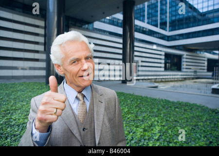 Deutschland, Baden Württemberg, Stuttgart, Senior Geschäftsmann macht Daumen hoch Zeichen, Porträt Stockfoto