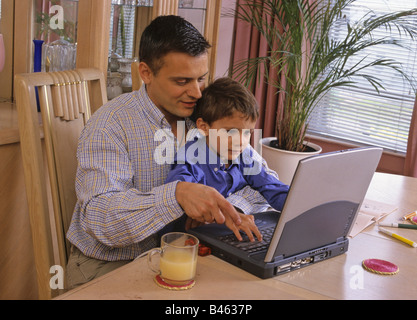 Vater und Sohn spielt auf laptop Stockfoto