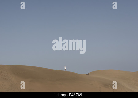 Eine einsame Frau steht auf einer Sanddüne in Maspalomas Gran Canaria Kanaren Spanien Stockfoto