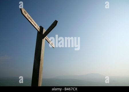 Wegweiser zu Ingleborough bei Sulber Nick mit Pen-y-Gent in der Ferne, Yorkshire Dales National Park, England. Stockfoto