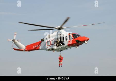 Küstenwache Suche und Rettung Hubschrauber auf Übung Windenbetrieb RNLI Mannschaftsmitglied Stockfoto