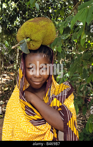 Eine Mädchen trägt eine Jackfrucht, Artocarpus Heterophyllus, die größte aller Baum trägt Früchte, Sansibar, Tansania Stockfoto